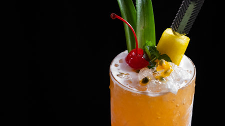 Cocktail with pineapple and cherry on a black backgroundの写真素材