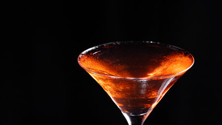 A glass of classic Manhattan cocktail on a black backgroundの写真素材