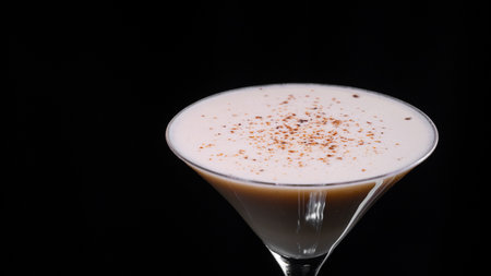 A glass of classic Alexander cocktail on a black backgroundの写真素材