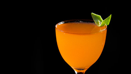Cocktail with orange juice and lime on a black background.の写真素材