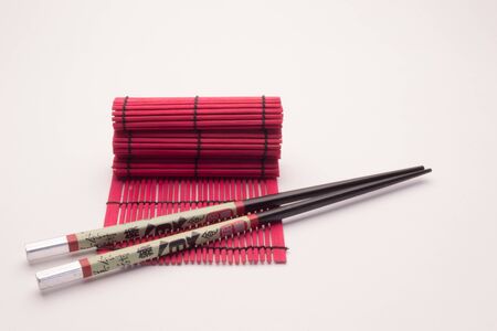 Oriental meal set, chopsticks ceramic glass and wicker red wooden standの写真素材