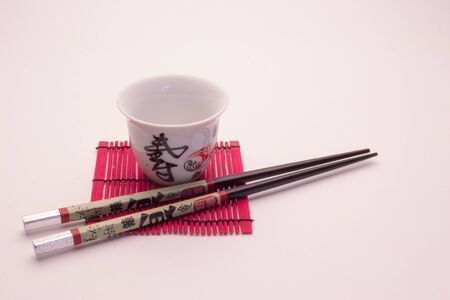 Oriental meal set, chopsticks ceramic glass and wicker red wooden standの写真素材