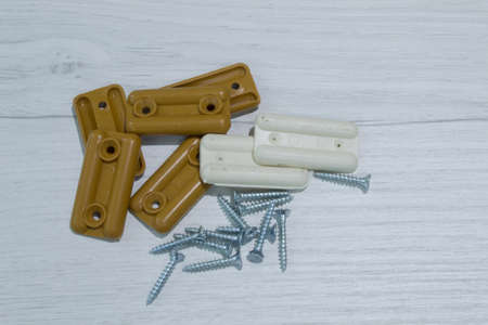 Furniture supports white and brown and self-tapping screws for fixing on a light wooden baseの写真素材