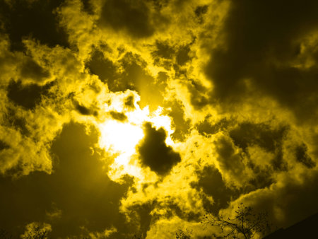 Yellow night cloudscape- Moon behind cloudsの写真素材