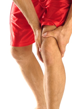 Injured athlete in pain clutches his kneeの写真素材