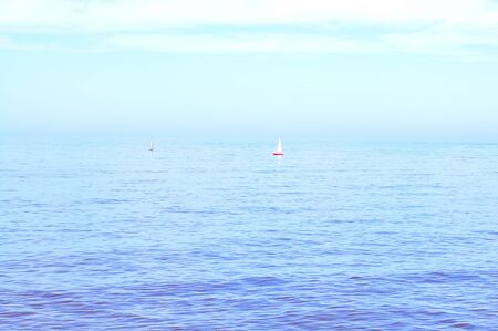 beautiful blue ocean with sailboats in distanceの写真素材