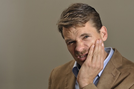 Man with toothache clutches jaw with handの写真素材