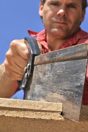 Inferior shot of hard working man sawing wood outdoorsの写真素材