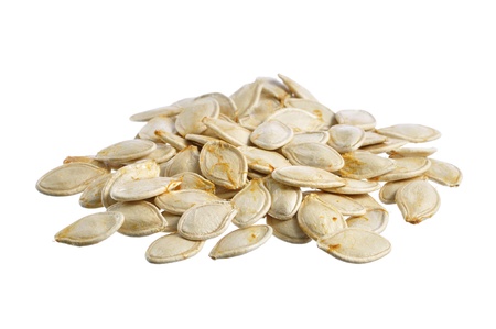 Closeup of pile of fresh raw whole pumpkin seeds isolated on whiteの写真素材