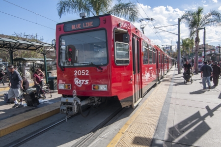 SAN YSIDRO, USA - NOVEMBER 27, 2013  Passengers board the San Diego blue line trolley at the southernmost station stop at the US - Mexico border crossing in San Ysidro on November 27, 2013   The blue line runs along Interstate 5 making numerous stops betwのeditorial素材