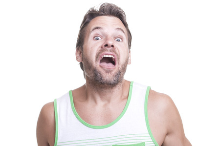 Crazy bearded Caucasian man in tank top makes strange weird expression on white background
の写真素材
