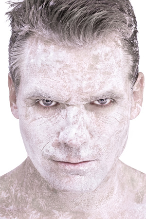 Closeup of serious Caucasian man with white flour powdered over entire face and neck on white backgroundの写真素材
