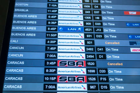 MIAMI, USA - MARCH 19, 2014  Monitor at Miami International Airport lists scheduled departing flights to Caracas, Cancun, Cali, Buenos Aires, Brasilia, and Boston and names of airlines traveling to these destinationsのeditorial素材