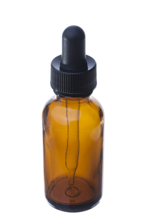 Closeup of amber glass dropper bottle with black cap isolated on whiteの写真素材