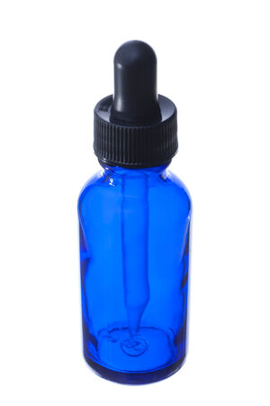 Closeup of blue glass dropper bottle with black cap isolated on white の写真素材