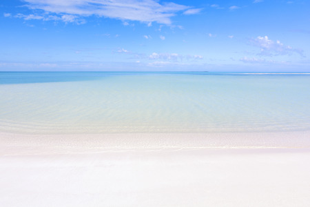 Beautiful clear turquoise water of lagoon and fine white sandy beach under blue sky at Isla Blanca...