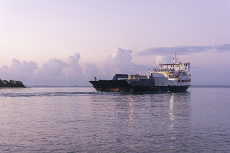 Cayo Largo ferry boat carrying cars and passengers leaves the port of Isla Culebra in direction of Fajardo, Puerto Rico on the Caribbean Sea early in the morningのeditorial素材