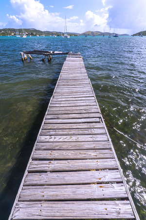 Long plank wood dock extends into quiet bay of Ensenada Honda on the Caribbean island of Isla Culebra in Puerto Ricoの写真素材