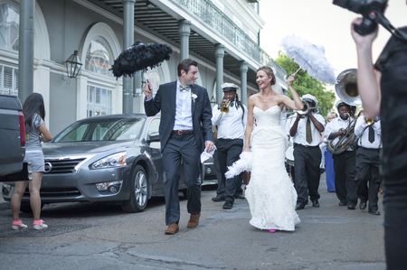 NEW ORLEANS, USA - OCTOBER 10, 2014: Happily newly wed bride and groom parade through the streets of the French Quarter in New Orleans followed by a jazz band in celebration of their union.のeditorial素材