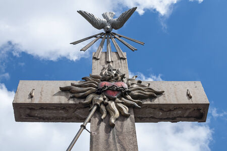 Beautiful ornate Cross of the Apostleship stands majestically in front of Chapel of Tepeyac in Mexico City with blue sky and white clouds in backgroundの写真素材