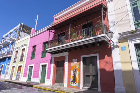 SAN JUAN, PUERTO RICO - JANUARY 29, 2014: Brightly colored colonial style buildings flank the cobblestone street of San Sebastian in historical Old San Juanのeditorial素材