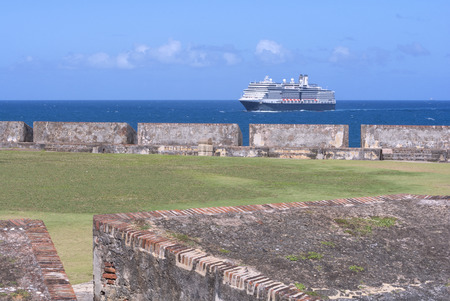 Huge passenger cruise ship in Atlantic Ocean behind protective walls of Fort San Felipe del Morro in Old San Juan, Puerto Ricoのeditorial素材