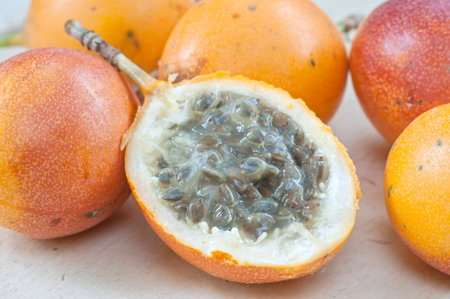 Closeup of fresh ripe Passiflora ligularis granadilla fruit sliced in half showing seedsの写真素材