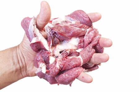 Closeup of human hand holding one pound of raw sliced beef on white backgroundの写真素材