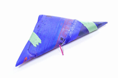 Closeup of single triangle shaped Mexican firecracker and fuse on white background