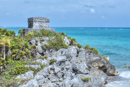 Maya structure Temple of the Wind stands alone on a cliff overlooking Caribbean Sea in Tulum, Mexicoの写真素材