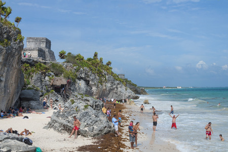 TULUM, MEXICO - JANUARY 23, 2015: Tourists enjoy the warm sunny weather on the beautiful Caribbean beach below the cliffs and Maya ruins of Tulumのeditorial素材