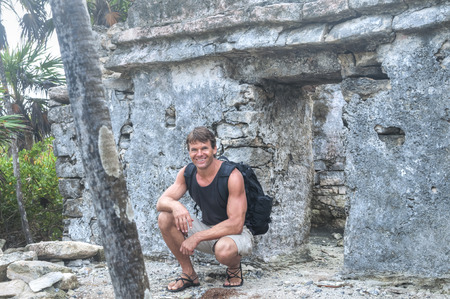 Handsome Caucasian male hiker poses in front of structure of old Maya ruins on Mexican Rivieraの写真素材