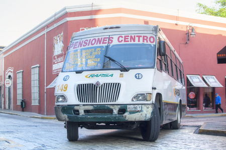 MERIDA, MEXICO - JANUARY 19, 2015: An urban white bus hurries through dowtown streets of Merida, Yucatan during morning rush hourのeditorial素材