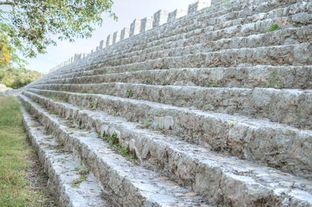 Shallow depth of focus and deep perspective along steps of Structure 44 in Central Square of archaeological site of Maya ruins in Dzibilchaltun near Merida, Mexicoの写真素材