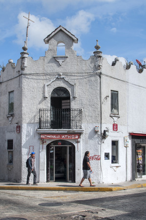 MERIDA, MEXICO - JANUARY 19, 2015: Tourists walk along sidewalk in front of old colonial style building on corner of streets 57 and 62 in Merida, Yucatanのeditorial素材
