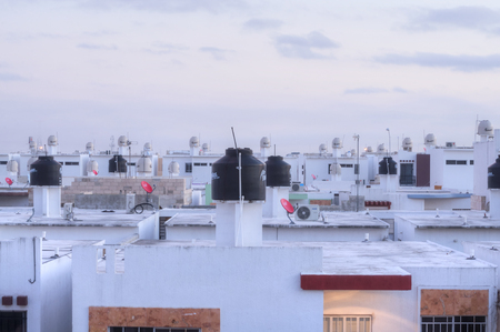 MERIDA, MEXICO - JANUARY 20, 2015: Water tanks sit on the rooftops of homes in a recently developed urban area of Merida, Yucatanのeditorial素材