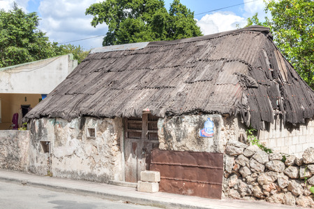 VALLADOLID, MEXICO - JANUARY 20, 2015: Obvious signs of wear are visible on this block and stucco home with rusty worn corrugated metal roof in Valladolid, Yucatanのeditorial素材