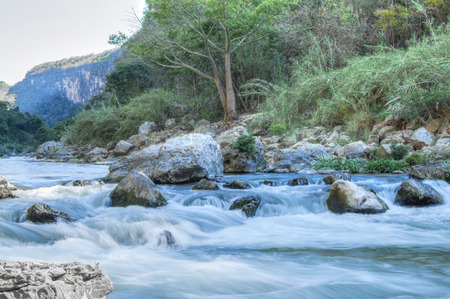 Slow shutter river water flowing over rocky rapids in tropical La Venta Canyon in Chiapas, Mexicoの写真素材