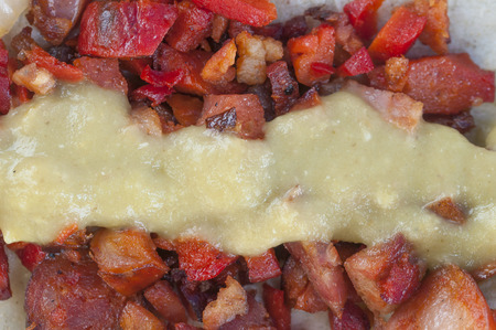 Macro closeup of greasy red Mexican chistorra pork meat covered with green salsa on a tortillaの写真素材