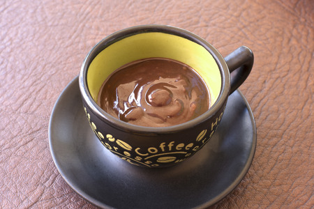 Cup of traditional thick Mexican chocolate fudge pudding on brown table topの写真素材