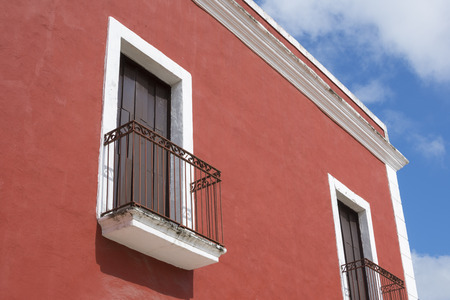 Closeup detail of upper corner of colorful colonial-style building in Valladolid, Mexico under sunny skyの写真素材