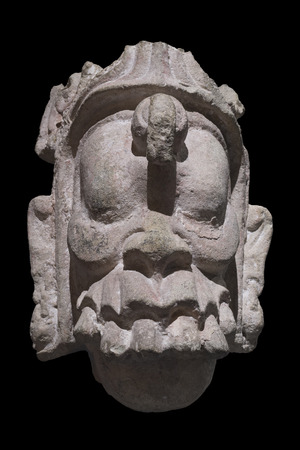 Closeup stone Mayan sculpture of head of supernatural being from Copan, Honduras isolated on black backgroundの写真素材