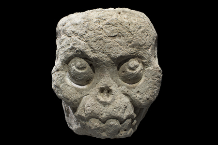 Closeup fleshless stone Mayan skull from Copan, Honduras isolated on black backgroundの写真素材