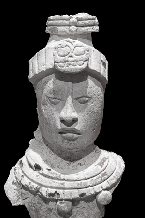 Sculpted stone head of Mayan god isolated on black backgroundの写真素材