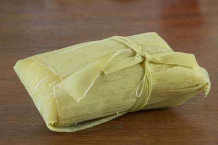 Closeup Brazilian pomonha dumpling consisting of sweet corn paste and wrapped in corn huskの写真素材