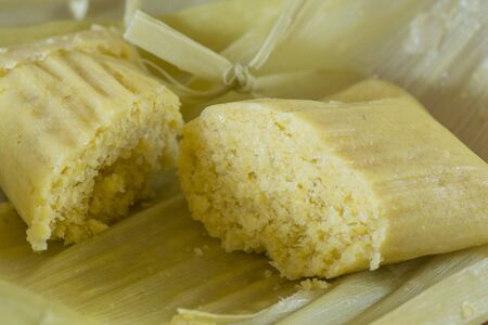 Closeup of unwrapped traditional Brazilian sweet corn dumpling on corn husksの写真素材