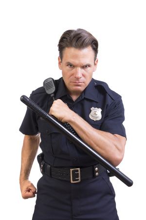 Handsome serious Caucasian police officer holding baton and charging forward aggressively on white backgroundの写真素材