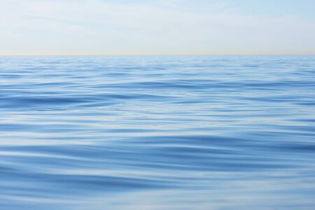 Shallow focus on gentle swell in endless calm sea with hazy horizon at La Jolla Shores, Californiaの写真素材