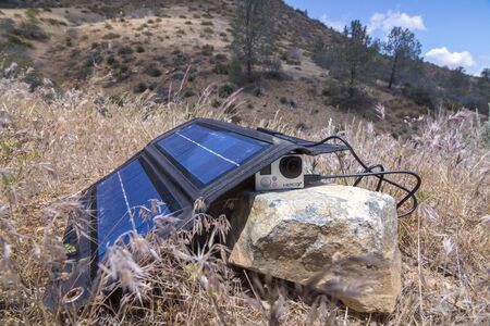 LAKE ISABELLA, USA - MAY 24, 2016: When hiking or living off the grid a folding solar charger is a...