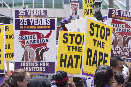 SAN DIEGO, USA - MAY 27, 2016: Protesters hold signs supporting wage increases for janitors while a supporter speaks to the crowd outside a Donald Trump rally at the San Diego Convention Center.のeditorial素材